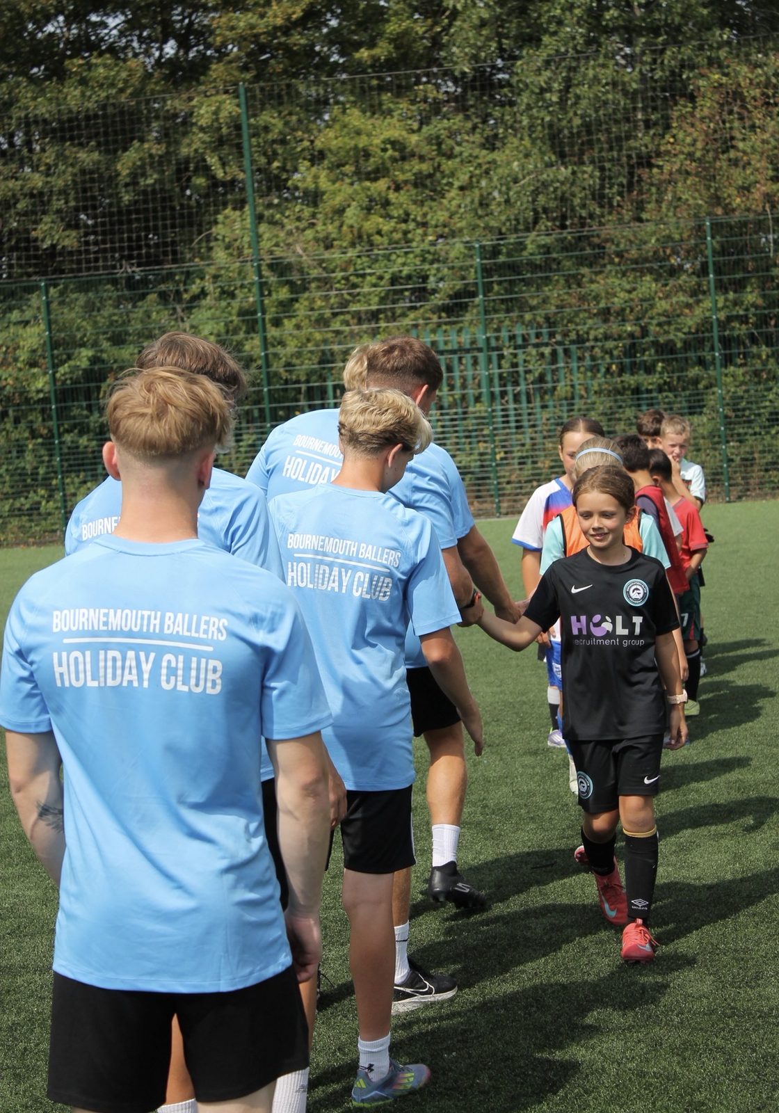 Bournemouth Ballers coaches walking out with children at a holiday camp session, Pelhams Park