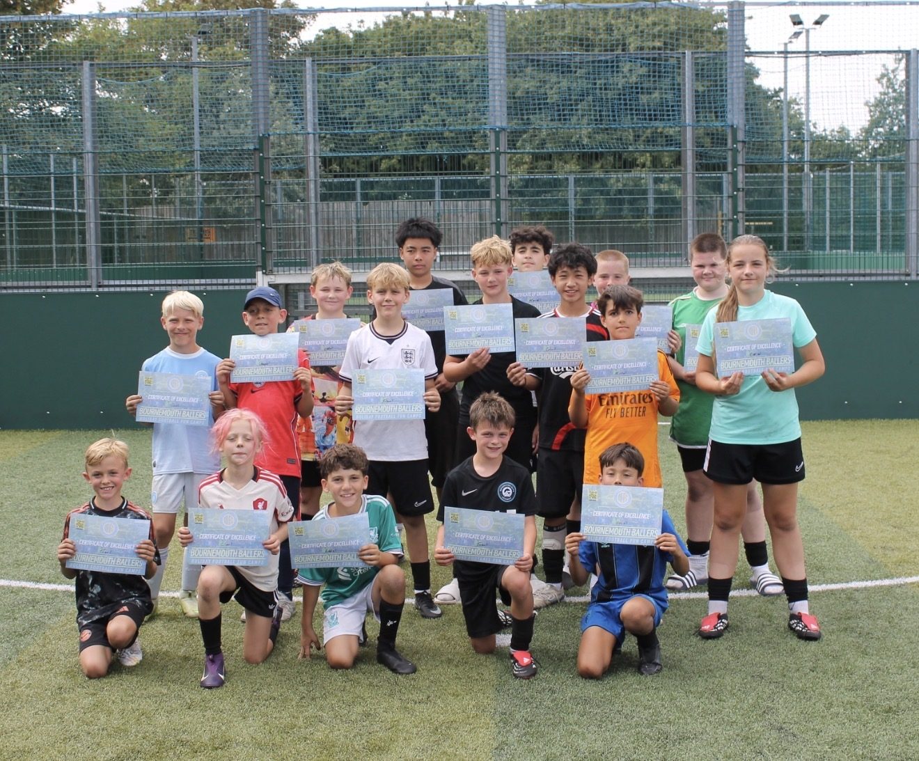 The whole camp holding up their Certificates of Excellence at the end of a summer camp day